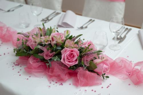 a bouquet of pink roses on a table at Hotel Chvalská Tvrz in Prague