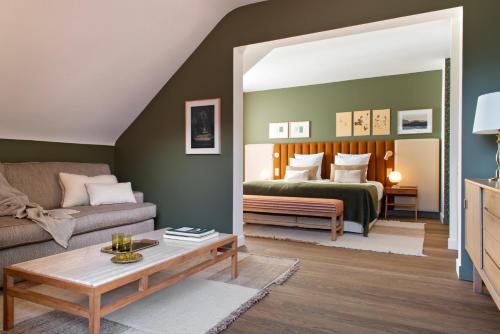 a living room with a bed and a couch at Auberge Du Père Bise - Jean Sulpice in Talloires