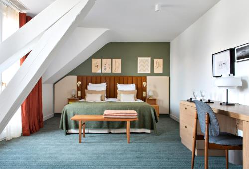 a bedroom with a bed and a table at Auberge Du Père Bise - Jean Sulpice in Talloires