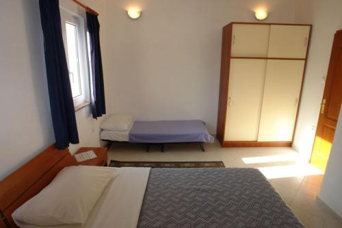 1 dormitorio con 2 camas y ventana en Apartments Tinka, en Povljana