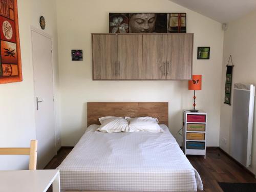 une chambre avec un lit et une armoire au-dessus dans l'établissement Les cottages de Magny, à Magny-les-Hameaux