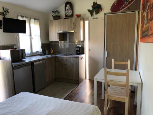 une cuisine avec des armoires en bois et une table et des chaises dans l'établissement Les cottages de Magny, à Magny-les-Hameaux