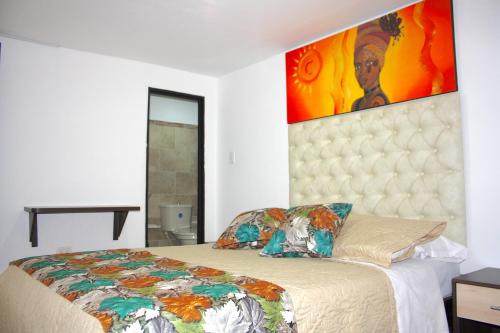 a bedroom with a bed with a large painting on the wall at Hotel San Blass in La Unión