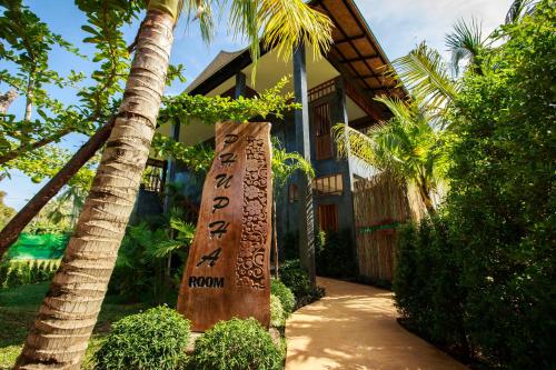 a sign in front of a house with a palm tree at Andalay Beach Resort Koh Libong in Ko Libong