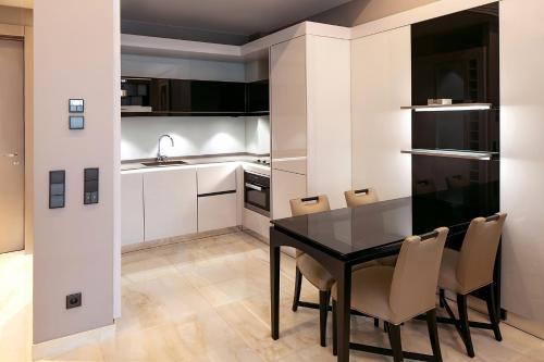 a kitchen with a dining room table and chairs at Alàbriga Hotel GL in S'Agaro