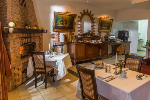 a dining room with two tables and a fireplace at VILLA RED by COLUMBUS Ustka in Ustka
