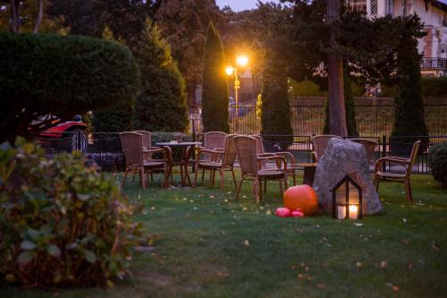 a yard with chairs and a small house in the grass at VILLA RED by COLUMBUS Ustka in Ustka