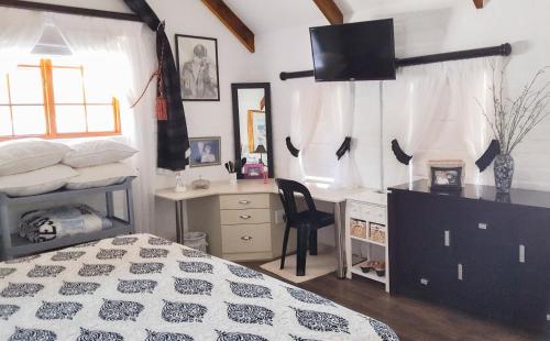 a bedroom with a bed and a desk and a deskablish at Myrtles Retreat in Stilbaai