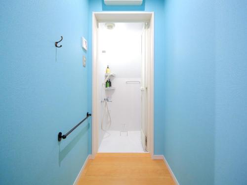 a bathroom with a blue wall and a white door at コージーイン 東京桜新町 in Tokyo