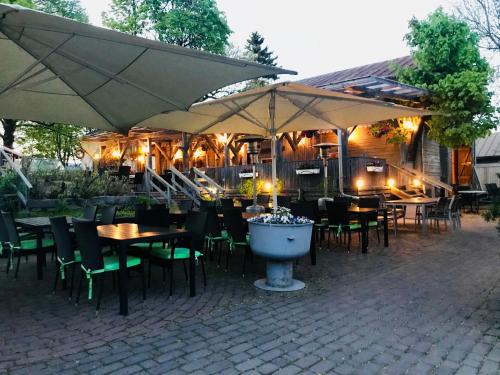 un restaurante al aire libre con mesas, sillas y sombrillas en Gasthaus Pooki en Uusikaupunki