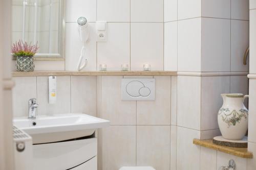 a bathroom with a sink and a toilet and a vase at VILLA RED by COLUMBUS Ustka in Ustka
