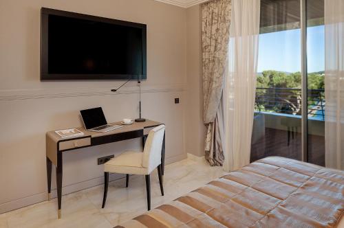 a bedroom with a desk with a laptop and a bed at Alàbriga Hotel GL in S'Agaro