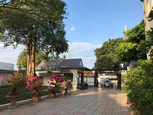 a courtyard with flowers and trees and a building at HOTEL AN HOÀ II in Ba Ria