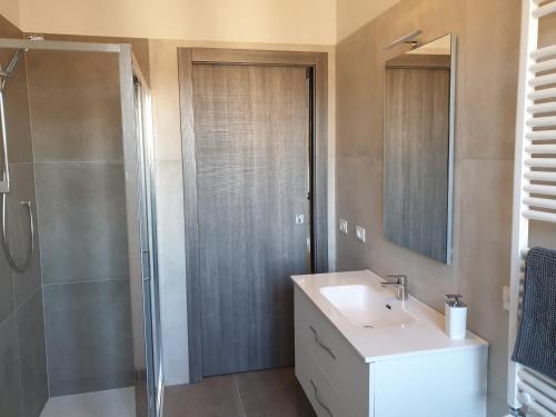 bagno con doccia, lavandino e specchio di Sun Lake Apartments a Desenzano del Garda