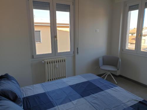 una camera con letto, sedia e finestre di Sun Lake Apartments a Desenzano del Garda