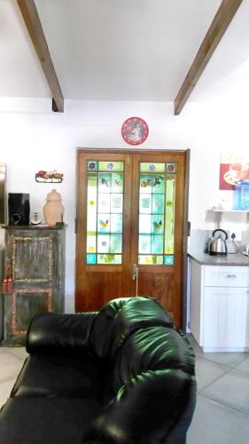 a living room with a couch in front of a door at Myrtles Retreat in Stilbaai