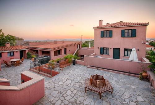 a patio with a table and bench on top of a house at The Varos Residences Hotel in Város