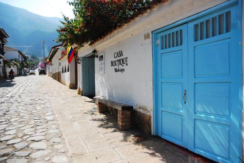een blauwe garagedeur op een wit gebouw op een straat bij Hotel Casa Boutique Villa de Leyva in Villa de Leyva