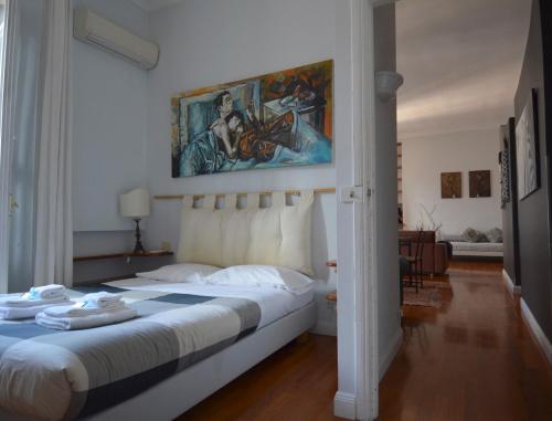 ローマにあるHouse and the City - Colosseum Apartmentsのベッドルーム1室(壁に絵画が描かれたベッド1台付)