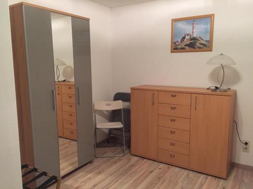 ein Schlafzimmer mit einem Spiegel, einer Kommode und einem Schreibtisch in der Unterkunft Am Ringwall 76 in Cuxhaven