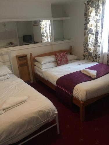two beds in a room with at Sandpiper Guest House in Brighton & Hove