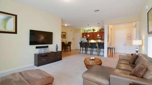 a living room with a couch and a flat screen tv at Chantilly Condo - closer to Disney and Universal in Orlando
