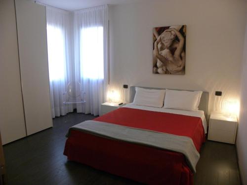 a bedroom with a large bed with a red blanket at Venice Apartments Dante in Mestre