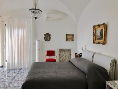 a bedroom with a bed and a red chair at Villa Silia in Capri