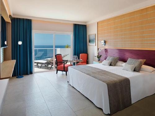 a hotel room with a bed and a view of the ocean at Adrián Hoteles Roca Nivaria in Adeje