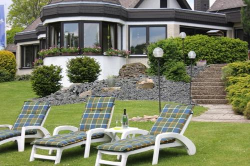 a group of lawn chairs and a bottle of wine at Landhotel Hubertus in Unterelsbach