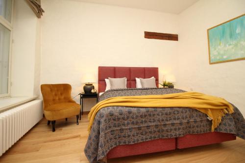 a bedroom with a large bed and a chair at Tallinn City Apartments Old Town Toompea in Tallinn