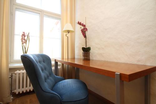 a desk and a blue chair in a room at Tallinn City Apartments Old Town Toompea in Tallinn
