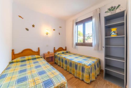 a bedroom with two beds and a window at Apartment Nerea in L'Escala