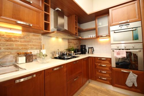 a kitchen with wooden cabinets and white counter tops at Tallinn City Apartments Old Town Toompea in Tallinn