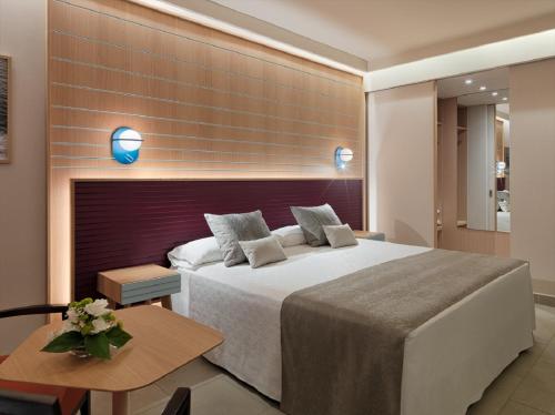 a bedroom with a large bed and a table at Adrián Hoteles Roca Nivaria in Adeje