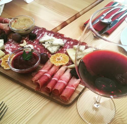 a plate of food and a glass of red wine at Hotel Boka in Bovec