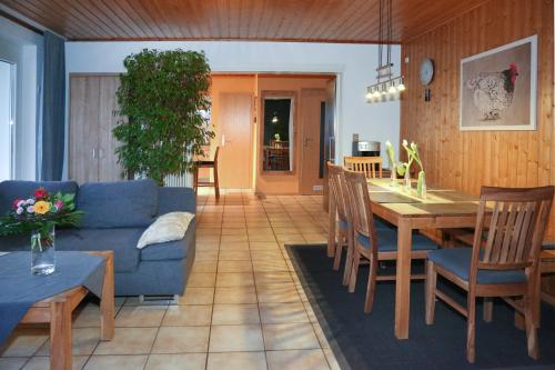 ein Wohnzimmer mit einem blauen Sofa und einem Tisch in der Unterkunft Ferienwohnung am Rain in Winden im Elztal
