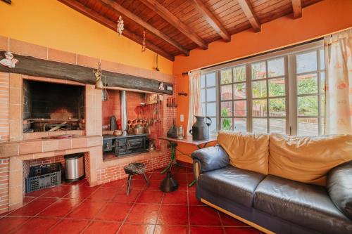 a living room with a leather couch and a fireplace at Villa Matta in Santana