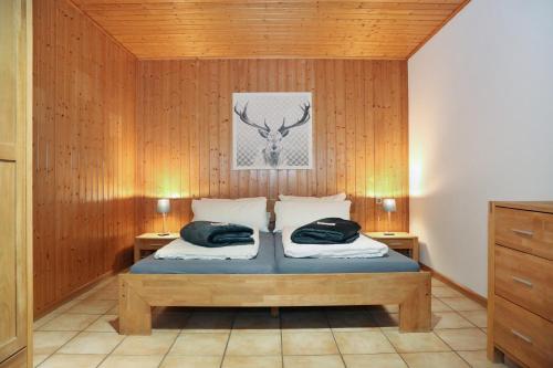 ヴィンデン・イム・エルツタールにあるFerienwohnung am Rainの木製の壁とベッドのある寝室