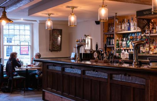 a bar in a pub with people sitting at tables at White Hart Inn in Wells