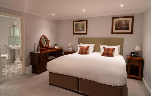 a bedroom with a large bed and a bathroom at White Hart Inn in Wells