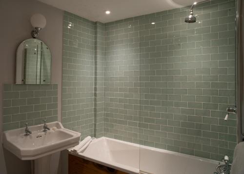 a bathroom with a sink and a bath tub at White Hart Inn in Wells