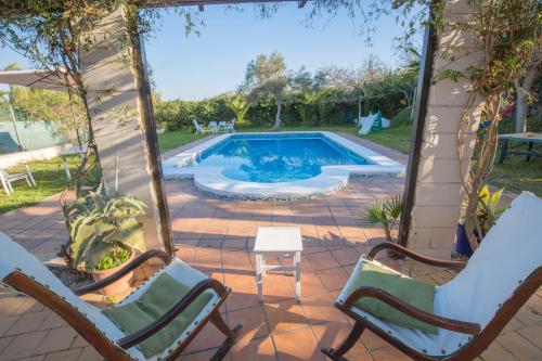 una piscina con due sedie e un tavolo di Villa Lago Sol a Torrevieja