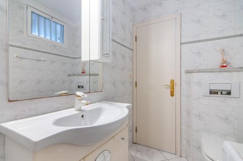 a white bathroom with a sink and a mirror at EL DORADO SEA VIEW 2A015 in Arona