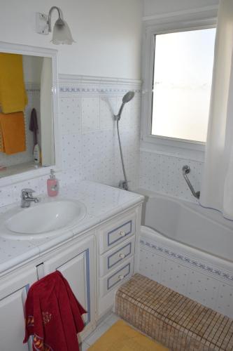 La salle de bains est pourvue d'un lavabo, d'une baignoire et d'une fenêtre. dans l'établissement Rue Roland Garros, à Fréjus
