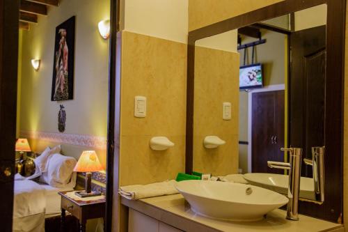 baño con lavabo y espejo grande en Yabar Hotel Plaza, en Cusco