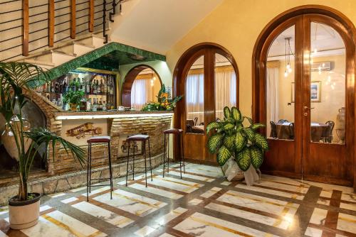 a restaurant with a bar with stools in a room at Hotel Santa Prisca in Rome