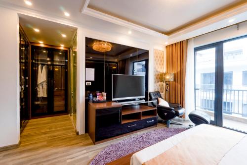 a hotel room with a bed and a television at BBQ HOSTEL in Ha Long