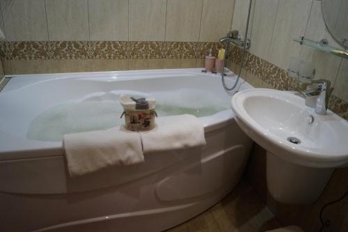 a bathroom with a bath tub and a sink at Schastie na Rubinsteina - Apartments in Saint Petersburg