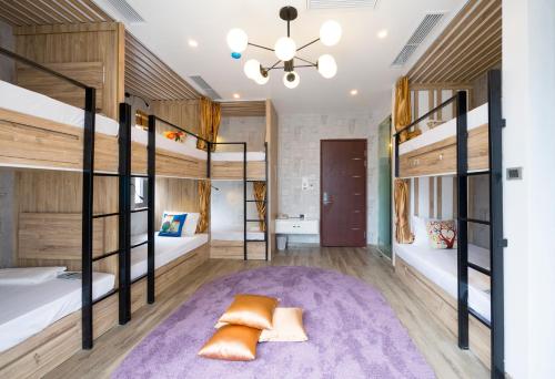 a room with four bunk beds and a purple rug at BBQ HOSTEL in Ha Long